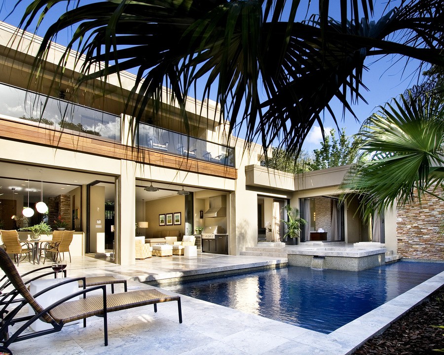 A contemporary pool with a lounge and dining area with hidden outdoor speakers.