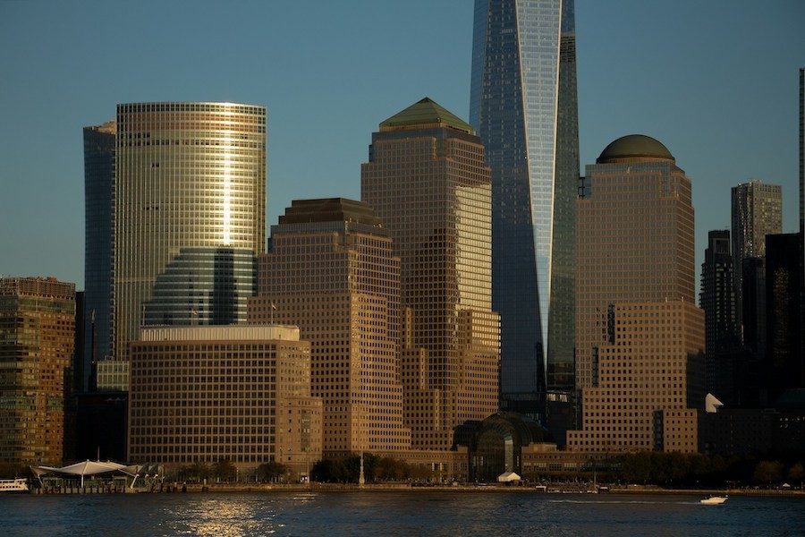  Manhattan skyline with golden sunlight reflecting off commercial buildings, highlighting the need for automated shades.