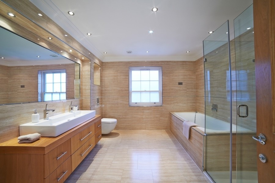 modernized bathroom with wood and tile finishes. Sleek lighting fixtures throughout the space.