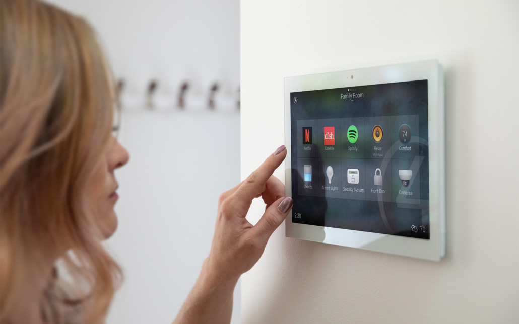 Woman Interacting With A Smart Home Tablet Base On Wall