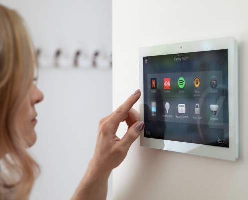 Woman Interacting With A Smart Home Tablet Base On Wall