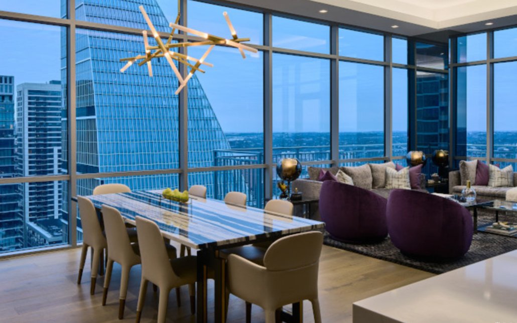 Side View Of Dining And Living Space In Panthouse Apartment With Floor To Ceiling Windows